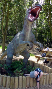 Josh posing with a dinosaur statue