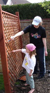 Misha painting the veggie garden fence with mum.