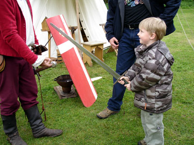 Joshua tries out a real sword at a medieval fair