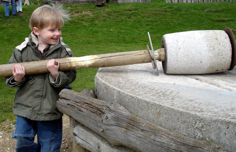 Josh tries his hand at the wheat mill