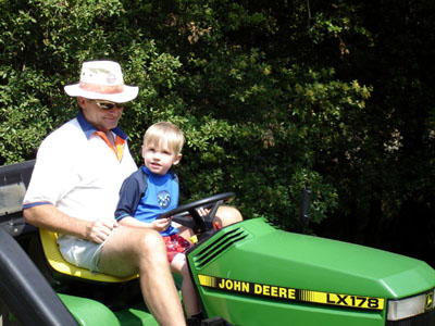 Grandpere taking Joshua for a spin on the lawn mower